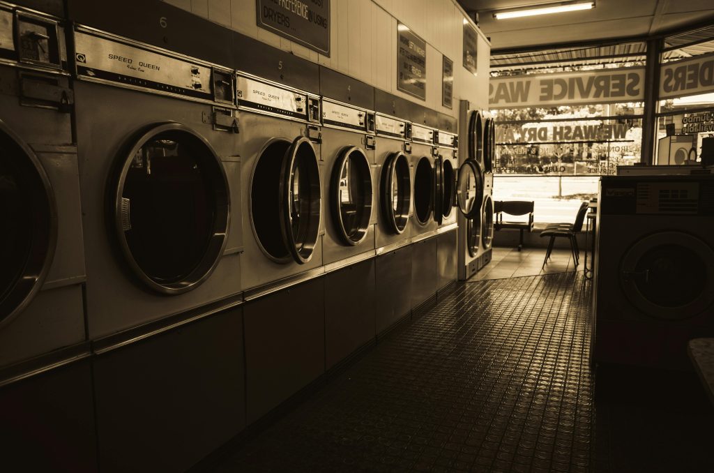 Sepia-toned photograph of a bank of older washers, photo by Sonny Sixteen.